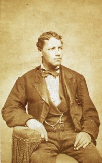 Studio portrait of unidentified seated young man, his left arm resting on chair, c1870-c1879. Creator: Unknown.