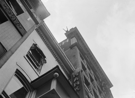 J. Reynolds, Performing Acrobatic And Balancing Acts On High Cornice Above 9th Street, N.W., 1917. Creator: Harris & Ewing.