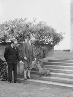 Kahn, Otto H., Mr., and unidentified man, with dog, standing outdoors, 1928 Creator: Arnold Genthe.