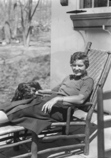 DeLamar, Alice, Miss, with dog, seated outdoors, between 1927 and 1942. Creator: Arnold Genthe.