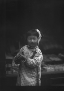 Young girl walking down the street, looking into the camera, Chinatown, San Francisco, c1896-c1906. Creator: Arnold Genthe.