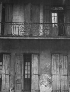 Facade of a building with shuttered doors and balcony, New Orleans or Charleston..., c1920-1926. Creator: Arnold Genthe.