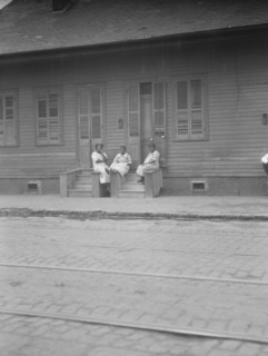 View from across street of three women talking, New Orleans or Charleston, South Ca., c1920-c1926. Creator: Arnold Genthe.