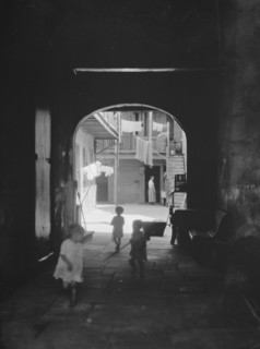 Children playing in an arched passageway, New Orleans, between 1920 and 1926. Creator: Arnold Genthe.