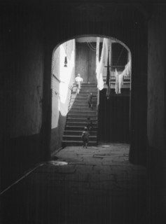 View of a courtyard through an arched passageway, New Orleans, between 1920 and 1926. Creator: Arnold Genthe.