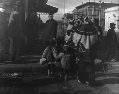 Women and children crossing a street, Chinatown, San Francisco, between 1896 and 1906. Creator: Arnold Genthe.