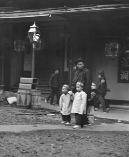 Man and two children crossing a street, Chinatown, San Francisco, between 1896 and 1906. Creator: Arnold Genthe.