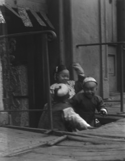 Three children in front of a cellar door, Chinatown, San Francisco, between 1896 and 1906. Creator: Arnold Genthe.