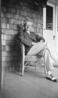 Arnold Genthe seated in a chair on a porch, between 1911 and 1942. Creator: Arnold Genthe.