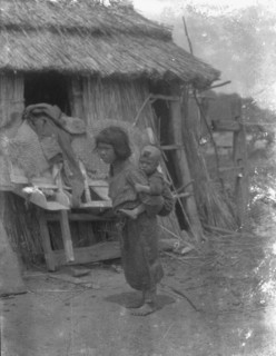 Ainu child carrying a baby on back, 1908. Creator: Arnold Genthe.