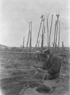 Ainu seated outside working on nets, 1908. Creator: Arnold Genthe.