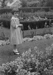 Truesdale, Virginia, Miss, standing in a garden, 1915 July 21. Creator: Arnold Genthe.