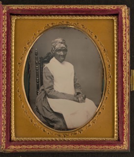 Unidentified African American woman in headscarf and apron, between 1850 and 1870. Creator: Unknown.