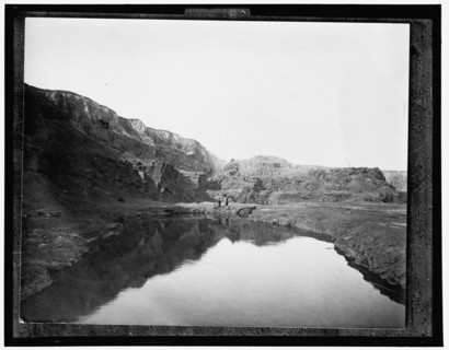 Two women by water, rocky cliffs in background, between 1900 and 1906. Creator: Unknown.