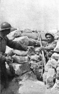 Life in the trenches in Champagne; A lookout 'teased' by the enemy is passed hand grenades, 1917. Creator: Unknown.