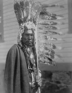 Piegan war-bonnet and coup-stick, c1910. Creator: Edward Sheriff Curtis.