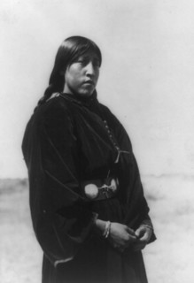 Arapaho maiden, three-quarter-length portrait, standing, facing right, c1910. Creator: Edward Sheriff Curtis.