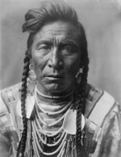 Strike On his Head, Crow Indian, Montana, head-and-shoulders portrait, facing front, loose..., c1908 Creator: Edward Sheriff Curtis.