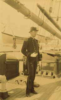 Unidentified naval officer, full-length portrait, standing aboard ship, facing right, 1894 or 1895. Creator: Alfred Lee Broadbent.