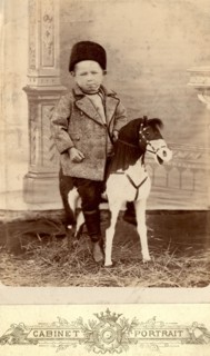 Portrait of a boy sitting on a toy horse, late 19th cent - early 20th cent. Creator: Unknown.