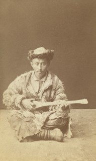 Kazakh man, a musician with a dombra, seated, between 1870 and 1886. Creator: Unknown.