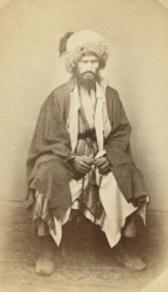 Full-length portrait of man, seated, facing front, between 1870 and 1886. Creator: Unknown.
