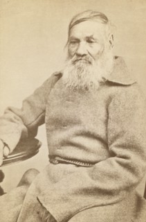 Three-quarter length portrait of an elderly convict, facing slightly left, between 1880 and 1886. Creator: Unknown.