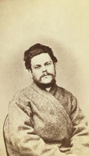Half-length portrait of a man, dressed in convict clothing, facing front, between 1880 and 1886. Creator: Unknown.