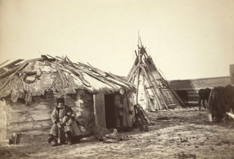 Tatar couple with a small boy in front of their home, between 1885 and 1886. Creator: Unknown.