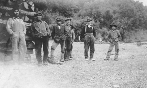 Men next to logs, between c1900 and 1916. Creator: Unknown.