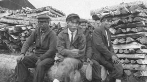 Men sitting on logs, between c1900 and 1916. Creator: Unknown.