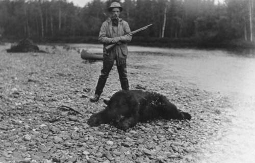 Hunter with bear which he killed, between c1900 and 1927. Creator: Unknown.