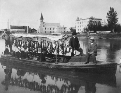 Marshall Erwin in front of a boat containing a kill of ducks, between c1900 and 1927. Creator: Unknown.