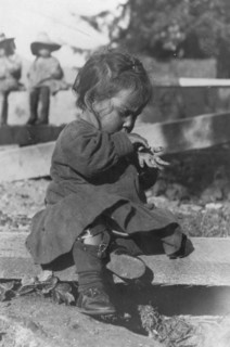 Young Eskimo child seated on board, between c1900 and c1930. Creator: Unknown.