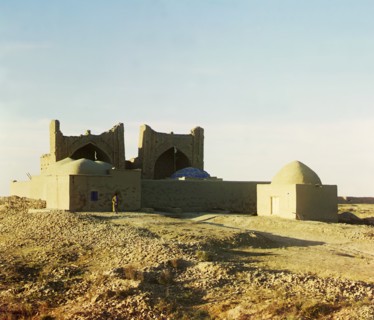 Walled adobe structure with domes and arches in desert area, with man posed..., between 1905-1915. Creator: Sergey Mikhaylovich Prokudin-Gorsky.