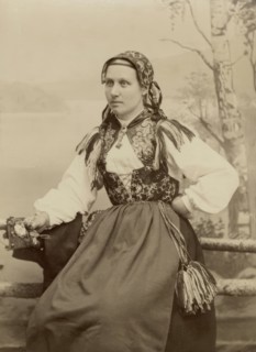 A young woman poses in a folk costume, 1890-1920. Creator: Helene Edlund.