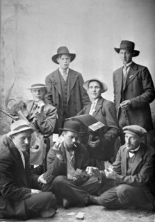 Group photo of men with musical instruments and playing cards, 1915.  Creator: Unknown.