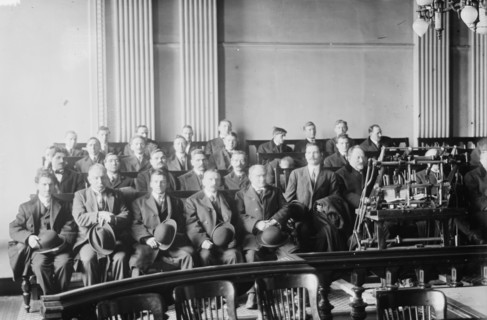Candidates for naturalization seated in room, hats in laps, 1916. Creator: Bain News Service.