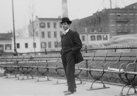 Umberto Blaisie standing in front of park benches, 1910. Creator: Bain News Service.