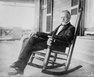 Sen. H.C. Lodge in rocker on porch, 1910. Creator: Bain News Service.