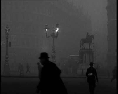 Male Civilians Walking Through the Foggy Streets of London, 1929. Creator: British Pathe Ltd.