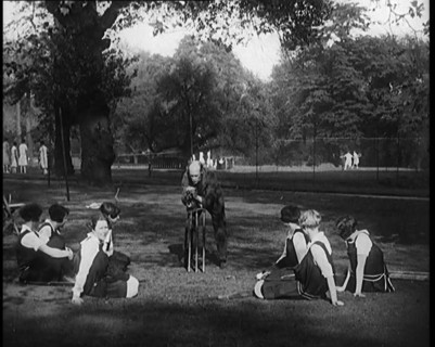 Male Civilian Demonstrating How to Set up a Cricket Wicket to a Group of Young Female..., 1920. Creator: British Pathe Ltd.