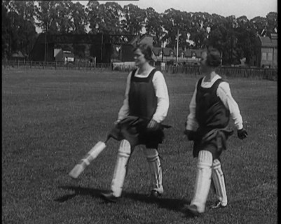 Two Female Civilians Wearing Gymslips and Batting Pads Holding Cricket Bats in a Playing Field, 1920 Creator: British Pathe Ltd.