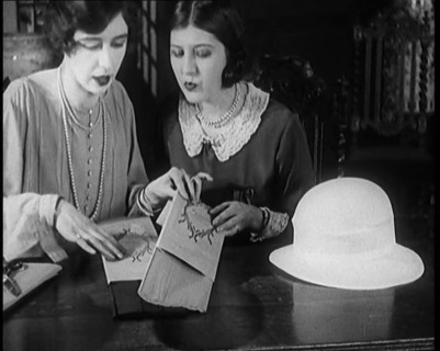Two Female Civilians Cutting  Sheets of Paper to Decorate a Hat, 1920. Creator: British Pathe Ltd.