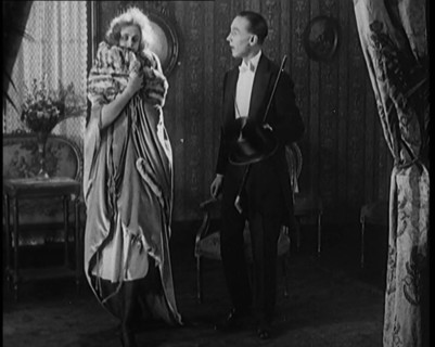 A Civilian Couple Wearing Evening Outfits Ready to Leave for an Event, the Male Holds a Top..., 1920 Creator: British Pathe Ltd.