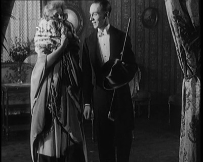 A Civilian Couple Wearing Evening Outfits Ready to Leave for an Event, the Male Holds a Top..., 1920 Creator: British Pathe Ltd.