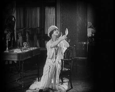 Female Civilian Seating in Front of a Dressing Table Wearing a Nightgown and Boudoir Cap..., 1920. Creator: British Pathe Ltd.