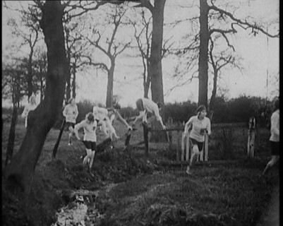 Young Female Civilians Wearing Sport Outfits Running Across a Field Jumping over Water in a..., 1920 Creator: British Pathe Ltd.