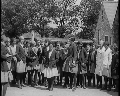 A Group of Young Female Civilians Wearing School Uniforms Standing in Front of a School, 1920. Creator: British Pathe Ltd.