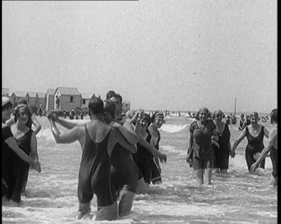 Civilians Wearing Swimsuits Enjoying a Sunny Day Dancing at a Very Crowded Beach, 1920. Creator: British Pathe Ltd.